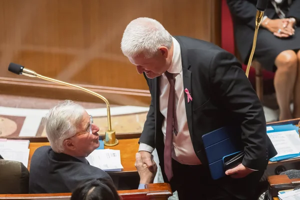 Poignée de main entre deux personnalités dans une salle d'assemblée parlementaire
