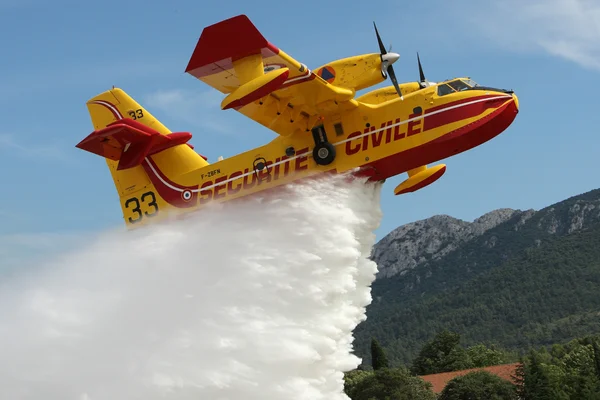 Un Canadair CL-415 de la Sécurité Civile en action de largage d'eau.