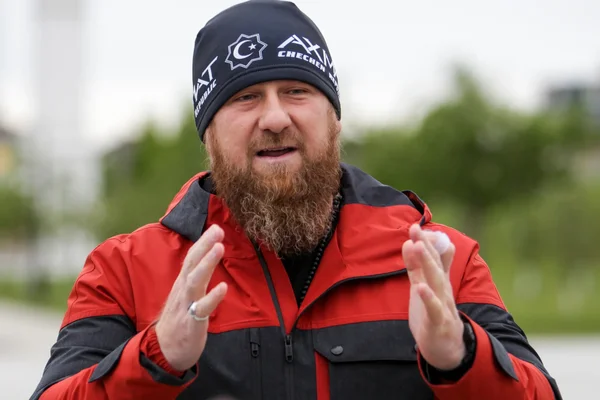 Ramzan Kadyrov faisant un geste, vêtu d'un bonnet et d'une veste aux couleurs tchétchènes.
