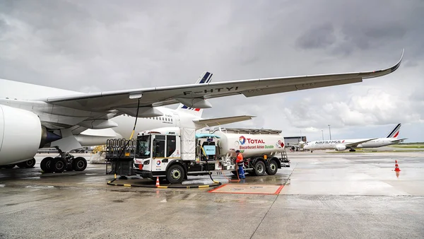 Un Airbus A380 d'Air France ravitaillé en kérosène par un camion Total sur le tarmac d'un aéroport.