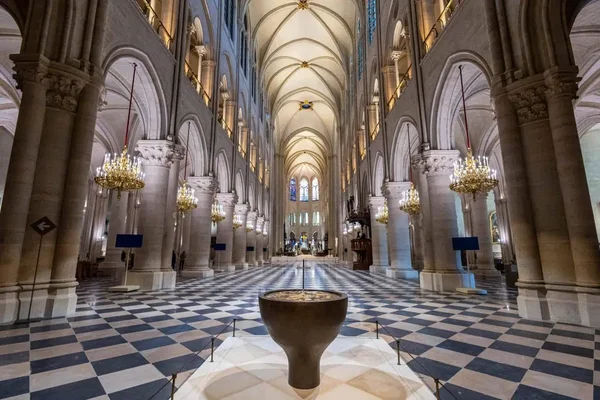 La nef de Notre-Dame de Paris avec son pavement en damier et ses lustres.
