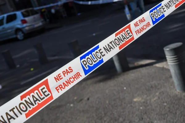Ruban de la Police nationale 'NE PAS FRANCHIR' bloquant une rue à Marseille après une fusillade.