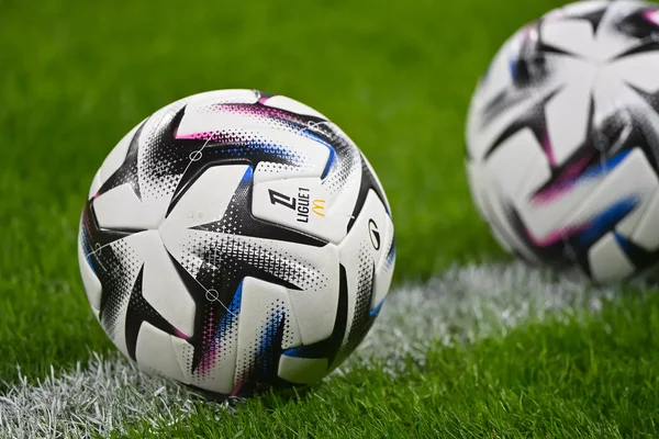 Ballons officiels de Ligue 1 McDonald's sur la pelouse.