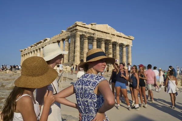 Touristes observant le Parthénon sur l'Acropole par une journée ensoleillée.