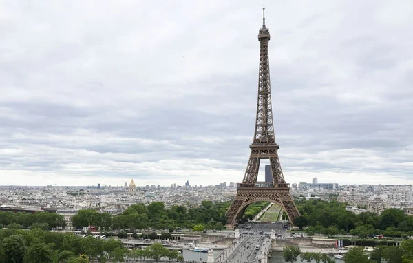 Vue d'ensemble de la tour Eiffel dominant le paysage parisien, avec la Seine et la ville en toile de fond