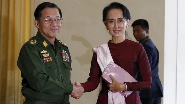 Min Aung Hlaing serrant la main d'une femme en tenue traditionnelle birmane