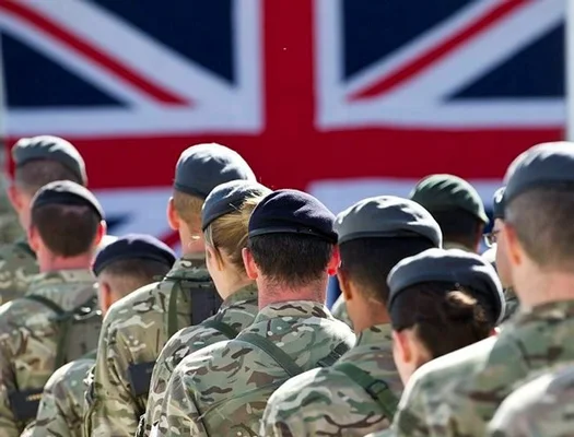 Soldats britanniques en formation devant le drapeau national, illustrant l'état des forces armées du Royaume-Uni.