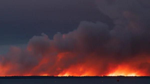 Incendie de forêt spectaculaire dans le Sud-Ouest, vu depuis un plan d'eau.