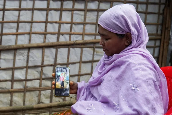 Une femme rohingya montrant la photo d'un enfant sur son smartphone.