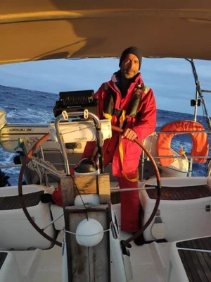 Julien Poublan naviguant dans des eaux agitées, à la barre de son voilier.