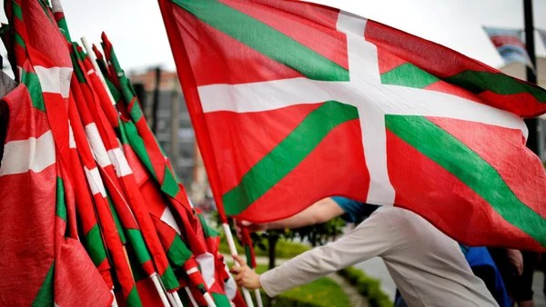 Une personne agitant le drapeau basque lors d'un rassemblement.