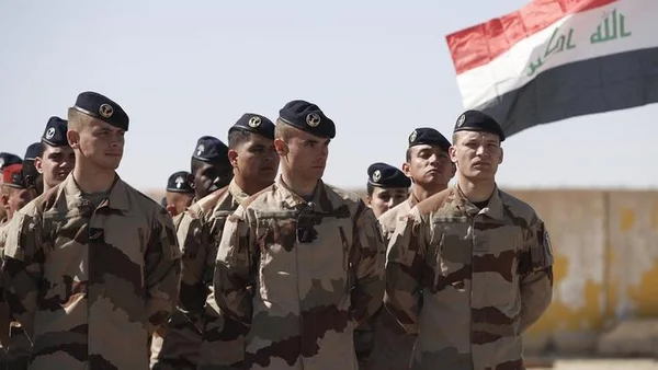 Des militaires français en formation en Irak, avec le drapeau irakien en arrière-plan.