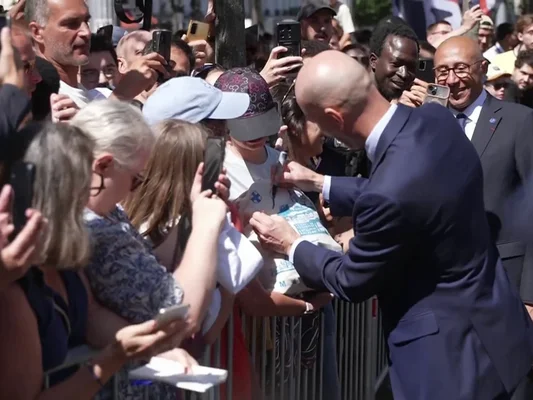 Zinédine Zidane signe un autographe pour un supporter devant la FFF.