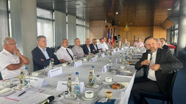 Réunion inaugurale du Conseil des cultes d'Alsace, avec des représentants religieux autour d'une table de conférence.
