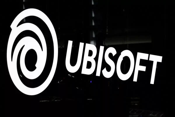 Logo lumineux d'Ubisoft sur fond sombre.
