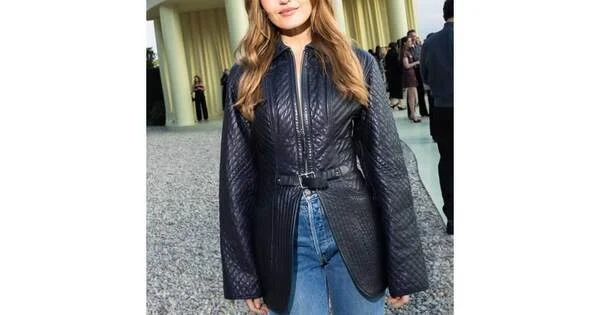 Chloe Fineman dans une veste en cuir noir, devant un bâtiment à colonnes.