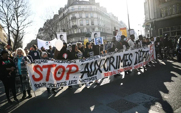 Manifestation à Paris contre le racisme et les violences policières, avec une banderole 'STOP AUX CRIMES D'ÉTAT'.