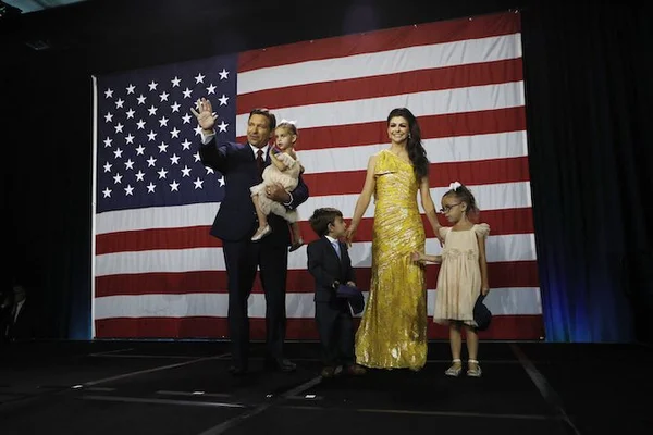 Une famille sur scène devant un drapeau américain, illustrant le nationalisme chrétien aux États-Unis.