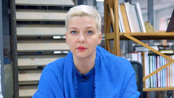 Portrait de Maria Kolesnikova dans un bureau avec une bibliothèque.