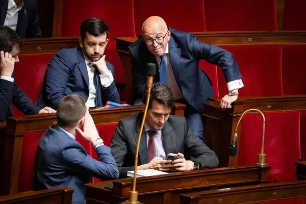 Des députés dans l'hémicycle, dont un regardant son téléphone, lors des débats sur l'Union des droites.