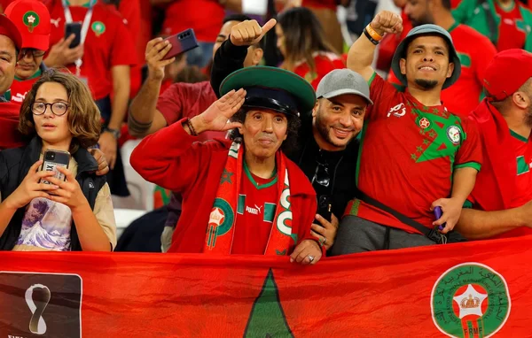 Supporters marocains célébrant dans un stade, avec un drapeau de la Fédération royale marocaine de football.