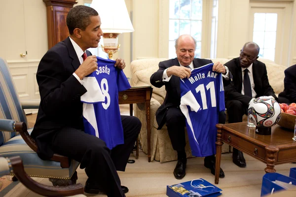 Barack Obama, Sepp Blatter et Jack Warner avec des maillots de football pour les filles d'Obama dans le Bureau ovale.