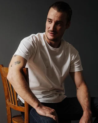 Pierre Lottin dans une séance photo décontractée, affichant ses tatouages.