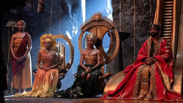 Scène du film Black Panther: Wakanda Forever montrant des personnages sur des trônes dans un décor bleu.