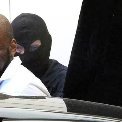 Un détenu encagoulé lors d'un transfert sécurisé.