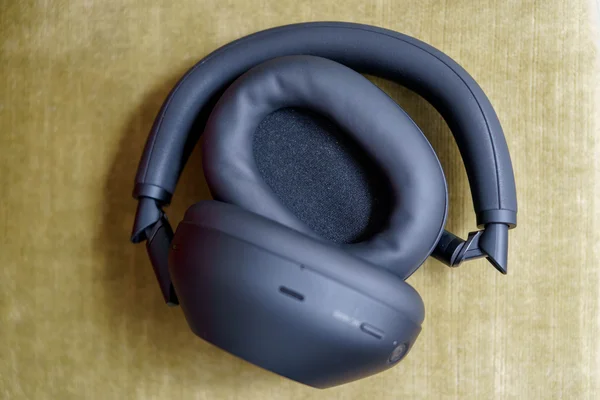 Gros plan du casque Sony WH-1000XM6 noir sur fond jaune texturé