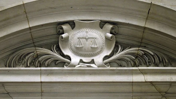 Détail architectural représentant la balance de la justice, symbole judiciaire.
