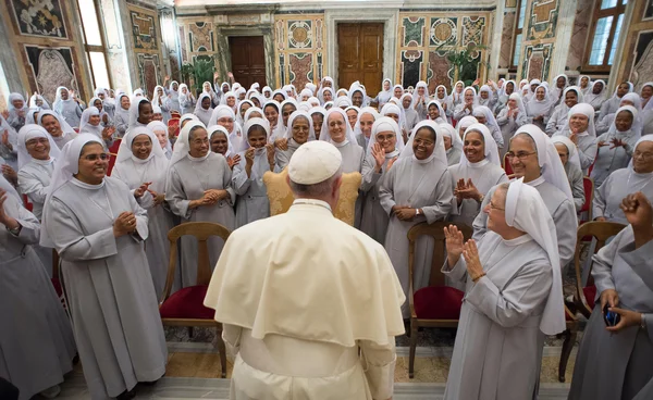 Des religieuses applaudissant un prélat lors d'une cérémonie.