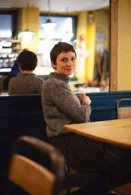 Phoebe Hadjimarkos Clarke dans un café, photographiée pour Society.