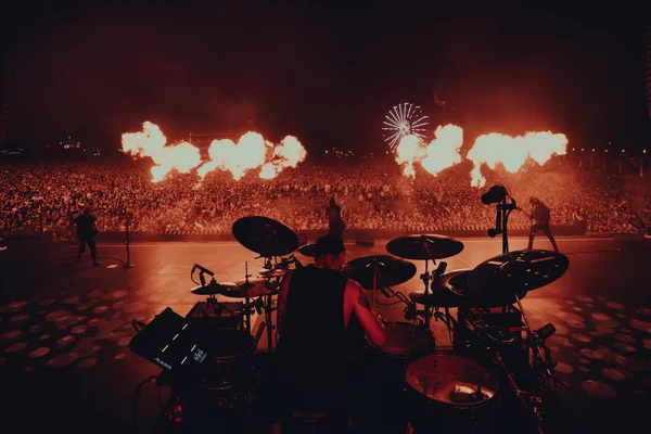 Un batteur sur scène au Hellfest 2026, avec une foule immense et des effets pyrotechniques.