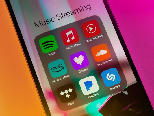 Dossier d'applications de streaming musical sur smartphone, illustrant le paysage numérique dans lequel Suno a puisé.