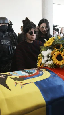 Femme en deuil près du cercueil de Fernando Villavicencio, recouvert du drapeau équatorien.
