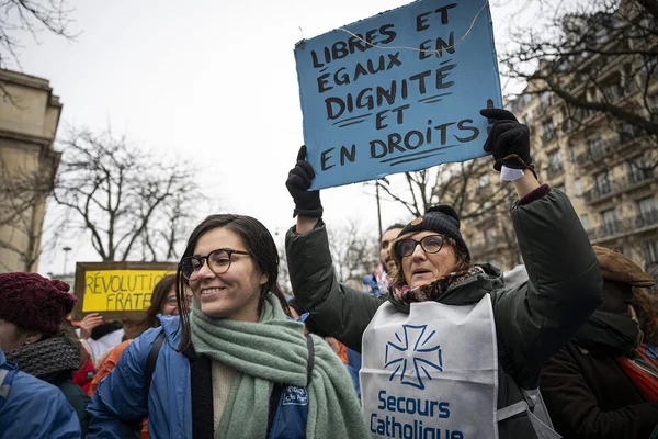 Manifestation pour les droits des sans-papiers, avec une pancarte 'Libres et égaux en dignité et en droits'.