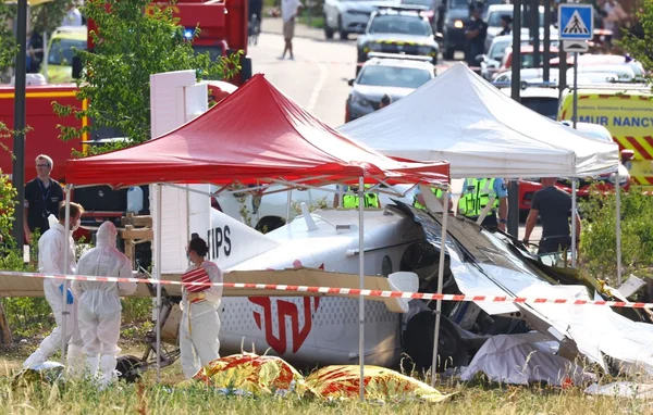 Enquêteurs et secouristes sur le site du crash, sous les tentes de protection.