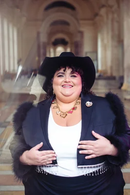 Barbara Butch, élégante avec un chapeau de cowboy et une veste à franges.