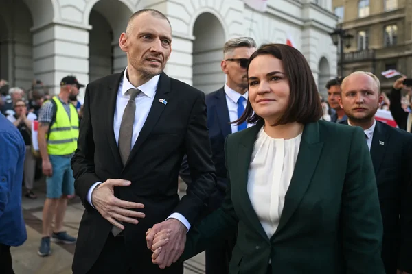 Svetlana Tikhanovskaïa, main dans la main avec un responsable, marchant à l'extérieur avec sa sécurité.