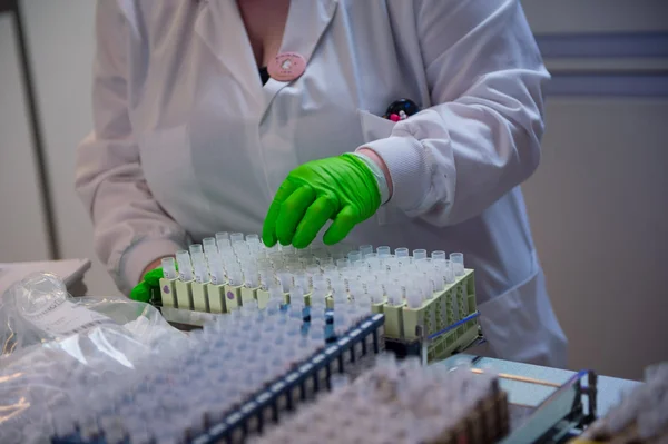Une technicienne de laboratoire manipule des échantillons dans un laboratoire d'analyses médicales.