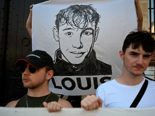 Des jeunes portent une banderole avec le portrait de Louis lors d'une marche blanche à Narbonne.