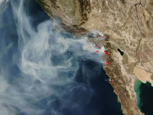Image satellite d'un panache de fumée de feux de forêt au large de la Californie, avec des marqueurs rouges pour les feux actifs.