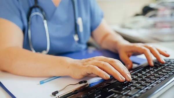 Un professionnel de santé travaillant sur un ordinateur, illustrant le contexte des données médicales compromises.