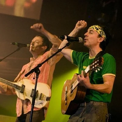 Raft sur scène : le chanteur à la guitare acoustique et un bassiste en action.