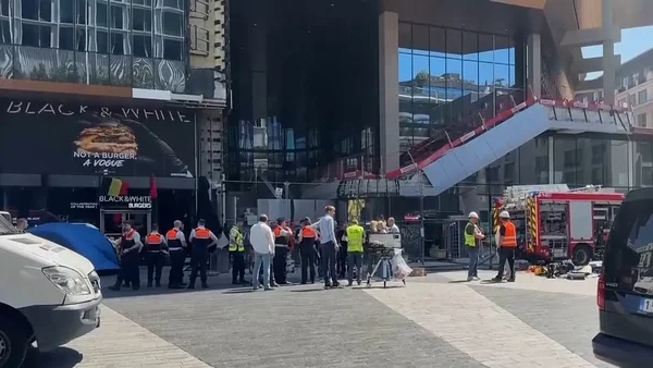 Pompiers et policiers sur les lieux de l'incendie, devant une structure effondrée près de la tour Oxy.