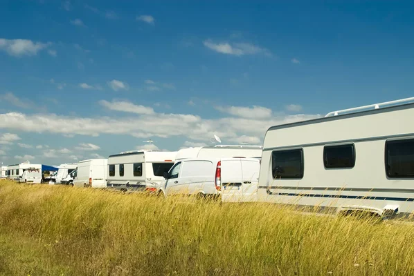 Des caravanes et camping-cars blancs installés dans un champ à Saint-Nazaire.