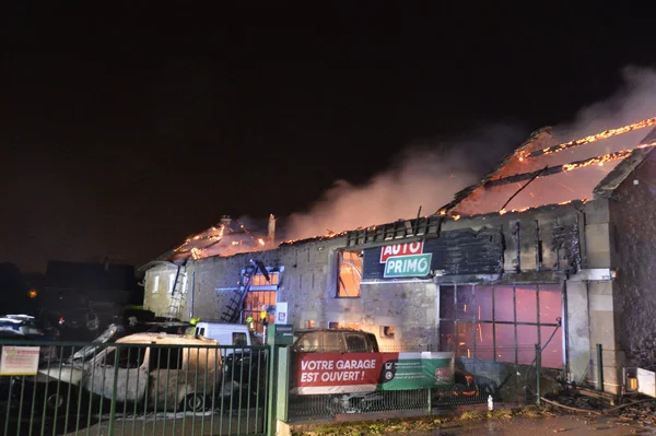 Un garage automobile entièrement détruit par les flammes à Autun, avec l'enseigne 'AUTO PRIMO' visible.