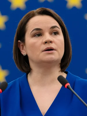 Svetlana Tsikhanovskaïa s'exprimant devant des micros, avec le drapeau européen en arrière-plan.