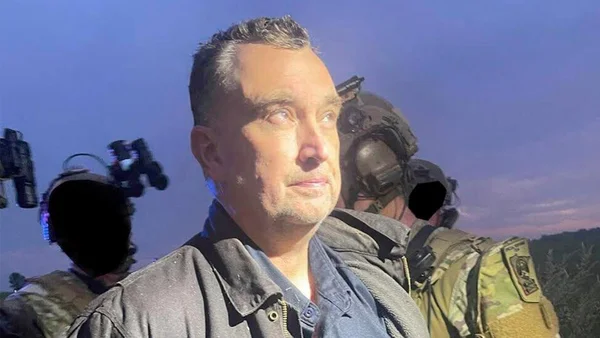 Le meurtrier présumé lors de son arrestation, avec des soldats en arrière-plan.